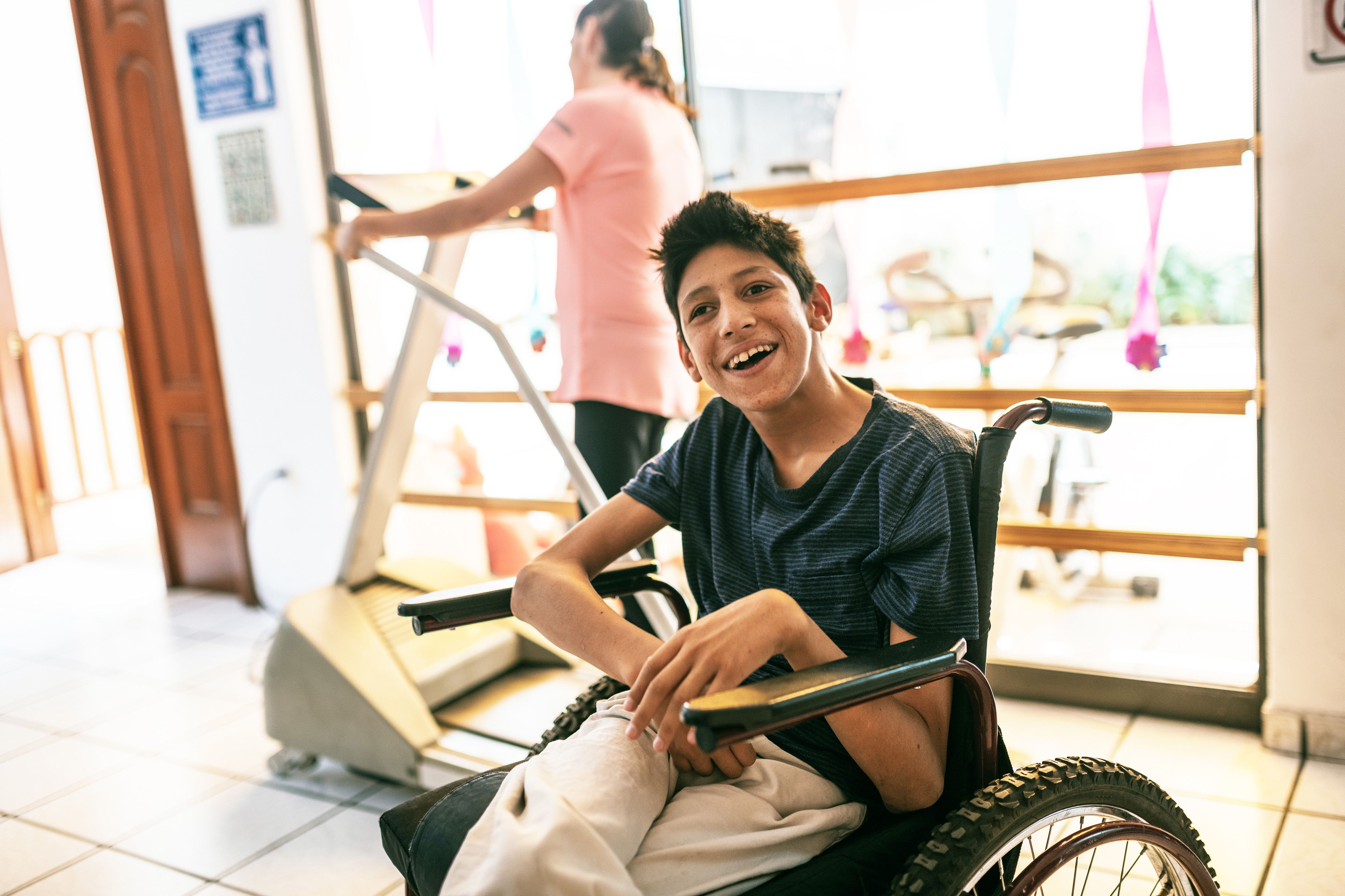 Young person in a wheelchair, in a gym